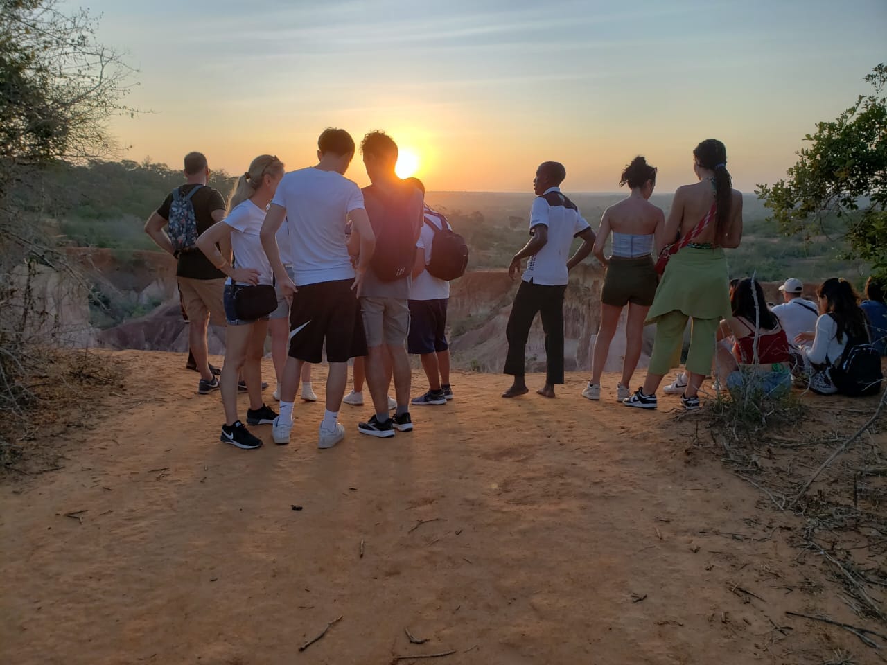 Gruppo di viaggiatori accompagnato durante il tramonto nella savana