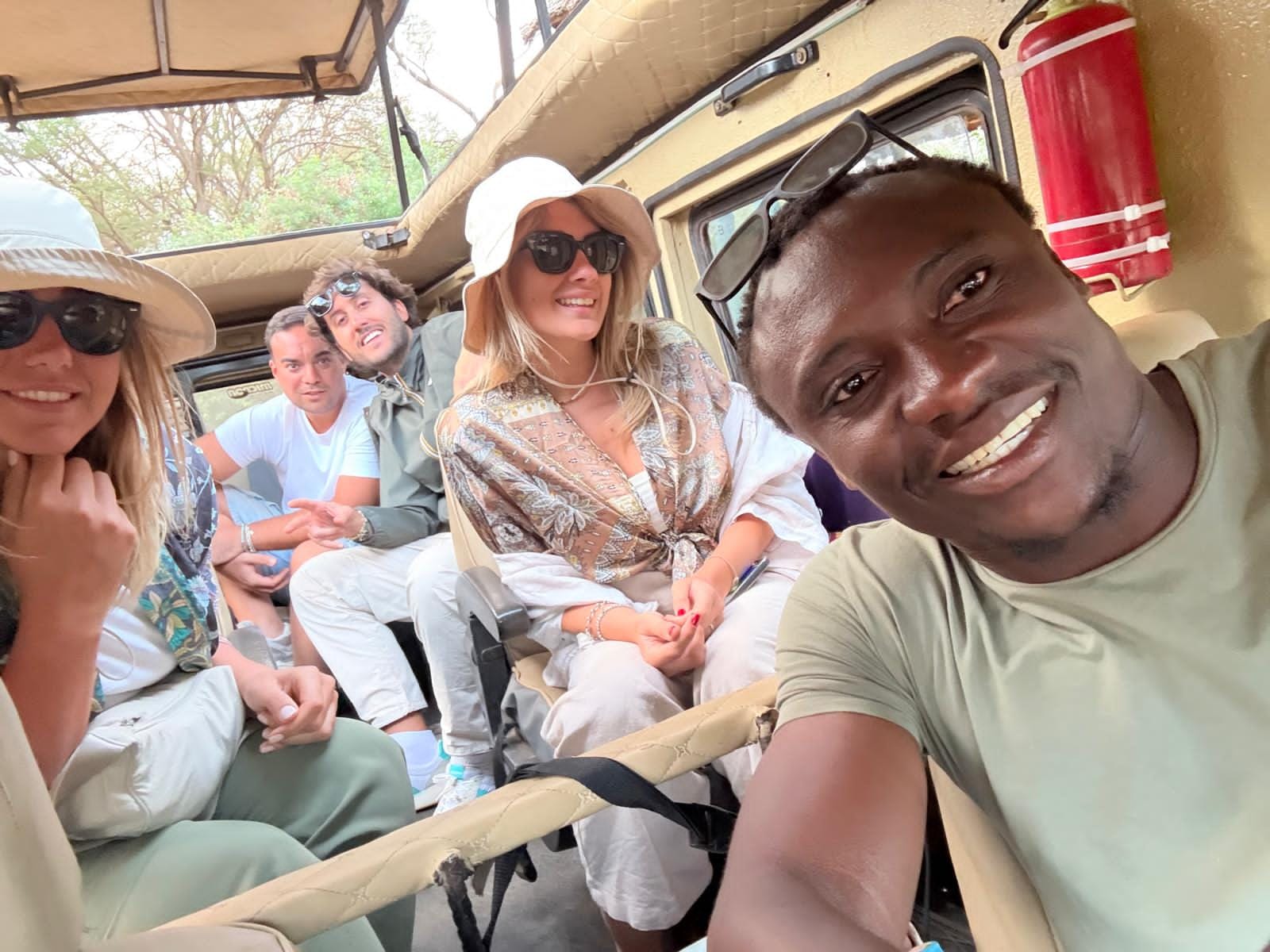 Branzino e il gruppo sorridenti all’interno della jeep da safari
